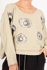 Beige sweater with circular pattern on a plain background
