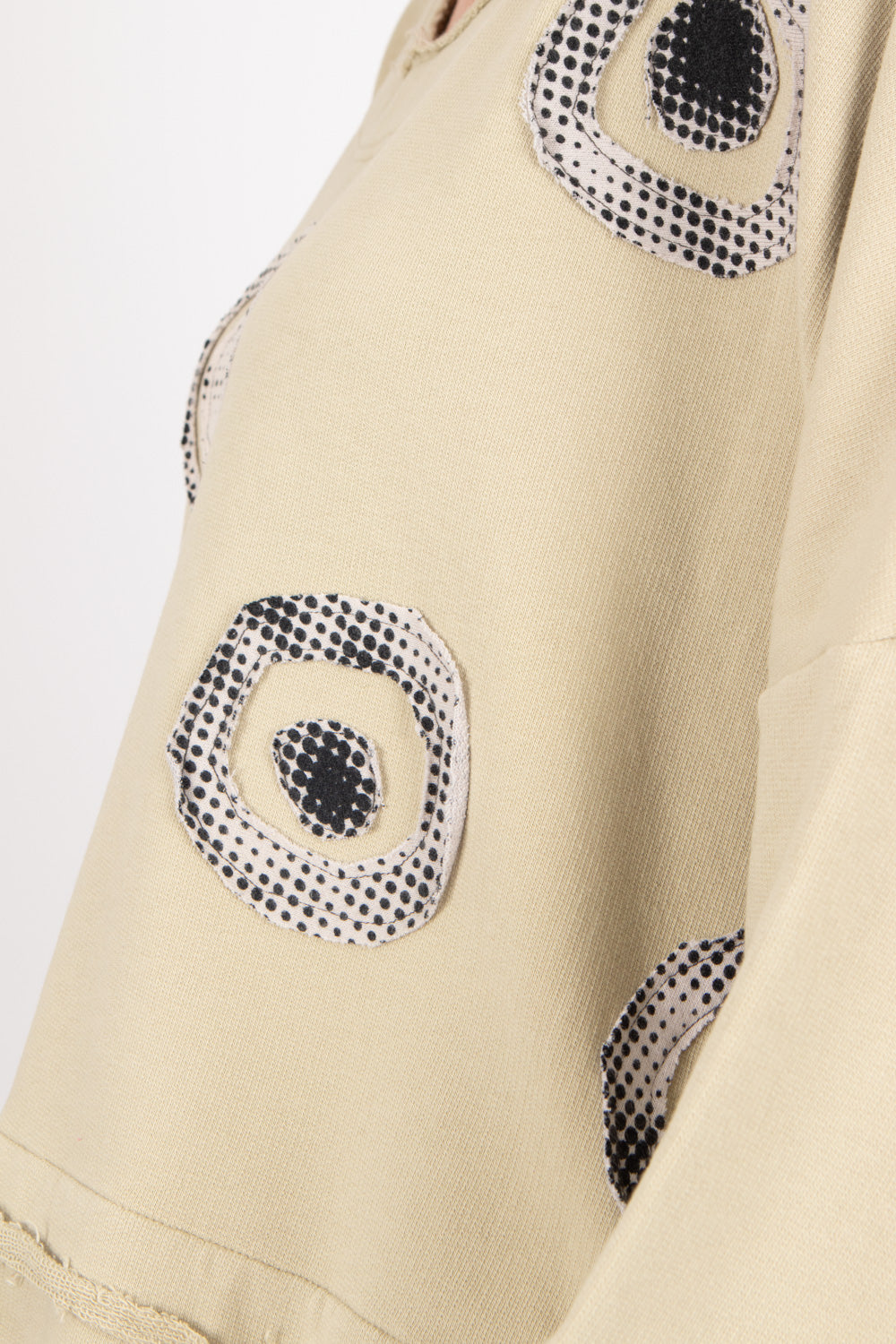 Beige fabric with black and white circular patterns on a light gray background