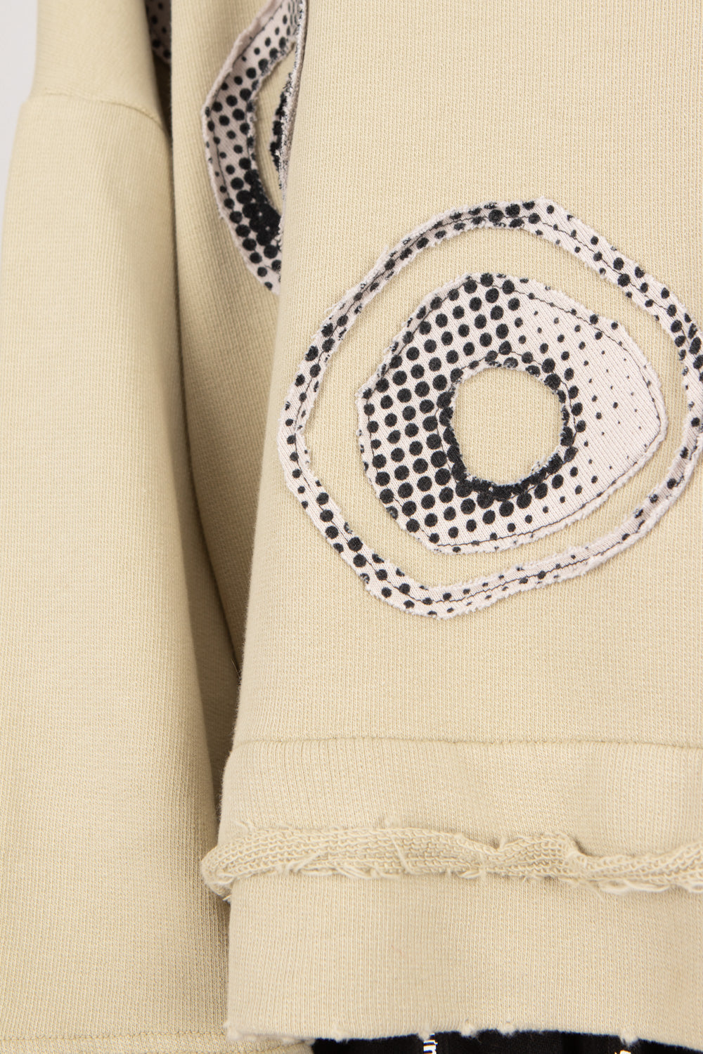 Close-up of a beige garment with black and white circular pattern