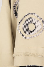 Close-up of a beige garment with black and white circular pattern